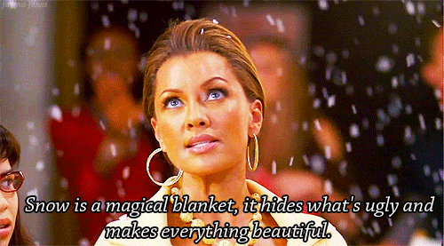 TV gif. Vanessa Williams as Wilhelmina Slater in Ugly Betty glances to America Ferrera as Betty Suarez next to her. Snow falls around them as Wilhelmina says “Snow, is a magical blanket, it hides what’s ugly and makes everything beautiful.”