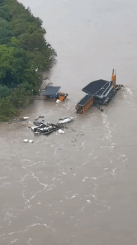 Debris From Jetty Floats Down Brisbane River Amid Deadly Flooding
