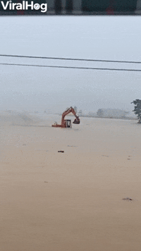 Excavator Returning to Shore Wades Against Floodwa