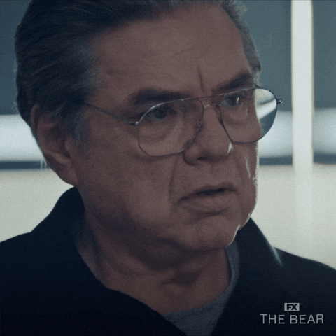 Uncle Jimmy from The Bear reacts bluntly, muttering “Yikes” with a look of dry concern and disbelief._nonprofit humour