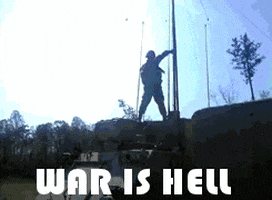 Video gif. Solider is dancing on a tank as bullet whiz by him. Text, "War is hell!"