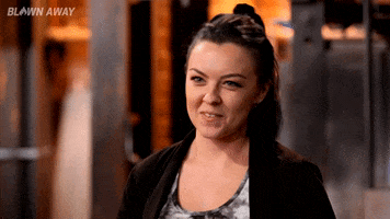 Reality TV gif. A contestant on Blown Away looks happy as she cheekily says, "Good," during an interview.
