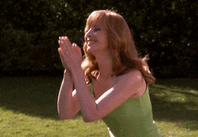 TV gif. Lisa Kudrow as Valerie in the Comeback smiles and bows with palms together in namaste.