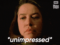 Sponsored gif. Actress Kathy Bates as Annie Wilkes from the movie Misery stares blankly while lightning flashes behind her. In the upper right corner is the AMC Fear Fest logo. Text reads, “Unimpressed.”