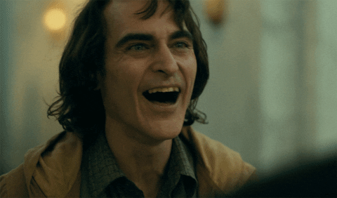 Movie gif. Throwing his head back, Joaquin Phoenix as The Joker laughs maniacally.