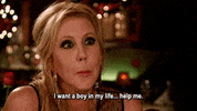 Reality TV gif. Vicki Gunvalson from Real Housewives of Orange County is chatting with someone at a restaurant and she stares at them while saying, "I want a boy in my life.. help me."