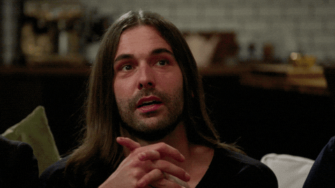 Reality TV gif. Jonathan Van Ness from Queer Eye is sitting with his hands folded together and he slowly purses his lips and raises his eyebrows, shaking his head slightly in acknowledgment, but not agreeing or disagreeing.