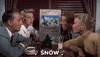 Movie gif. Crowded into a diner booth, Bing Crosby, Danny Kaye, Rosemary Clooney, and Vera Ellen as Bob, Phil, Betty, and Judy in White Christmas sing together while smiling. Text, "snow."