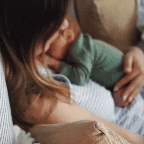 A person cradling a baby in their arms.
