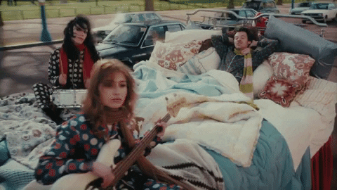 colchão em espanhol

DESCRIÇÃO DA IMAGEM: Cena do clipe "Late Night Talking". O cantor britânico Harry Styles está em uma "cama viajante" passando na frente de um parque. Há duas mulheres com ele, uma tocando o tambor de uma bateria e outra tocando violão. Todos usam pijamas de frio de bolinhas e cachecol. Na cama, vemos várias almofadas e travesseiros, além de pelo menos dois cobertores. 