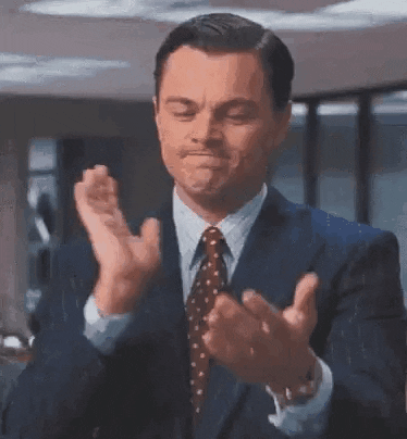 Movie gif. Leonardo DiCaprio as Jordan in Wolf of Wall Street stands in an office wearing a dark blue suit jacket. With a bitter facial expression and downcast, avoidant eyes, he claps emphatically.