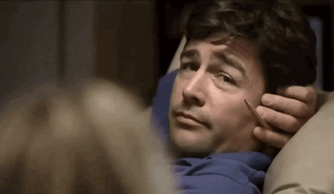 TV gif. Kyle Chandler as Eric Taylor leans back in a reclining chair. His arm is behind his head and in his same hand he holds a pencil. He looks over at Connie Britton as Tami Taylor with an ernest smile and then winks. 