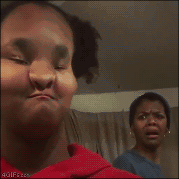 Video gif. Mother reacts in horror to a filter on her child’s face that makes her mouth and nose look pinched, then the child zooms in on her mom’s face, and her face takes on the filter, pinching her already horrified look.