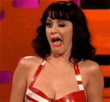 Celebrity gif. Wearing a red and white-striped halter top, Katy Perry winks awkwardly and obviously, with her mouth cracked open.