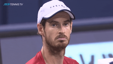 Sports gif. Andy Murray stares at us blankly and shrugs.