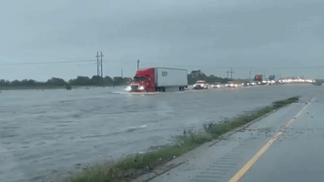 Vehicles Crawl Along Flooded Southeastern Texas Highway