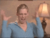Video gif. We quickly zoom in on a woman raising her hands to the side of her head as she screams in anger. 
