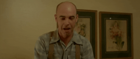 Movie gif. Jason Thompson as Spencer in Antiquities raises up two empty liquor bottles with both hands and acts like he's pouring their contents into his mouth.