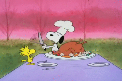 Peanuts gif. Snoopy has a chef's hat on and is sharpening a knife. He has a turkey in front of him and he begins carving into it enthusiastically as Woodstock looks at him in anticipation and happiness as they celebrate Thanksgiving together. 