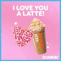Sponsored gif. Pink heart-shaped donut covered in sprinkles presses against an elaborate iced coffee drink topped with whipped cream from Dunkin’ Donuts. Text above them reads, “I love you a latte!”