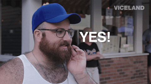 TV gif. In a "man on the street" interview, a bearded man with glasses, wearing a sleeveless white shirt and a blank blue cap, emphatically agrees. Text follows his hand as he punctuates his speech: "Yes!"