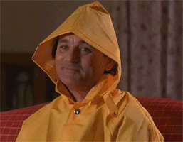 Celebrity gif. Bill Murray as Bob in What About Bob? wears a yellow rain slicker with the hood up as he laughs sheepishly and shrugs, then says, "K."