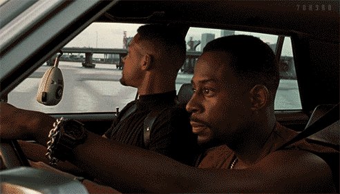 Movie gif. From the movie Bad Boys, Martin Lawrence as Marcus, driving the car with Will Smith as Mike, singing along to something.  