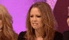Video TV gif. Woman grimaces before shaking her head in disgust, in front of a blingy, hot pink backdrop