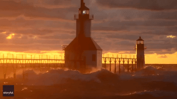 Waves Crash Against Lake Michigan Lighthouse During Golden Sunset