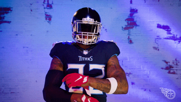 Sports gif. Derrick Henry of the Tennessee Titans wears his helmet and shrugs at us.