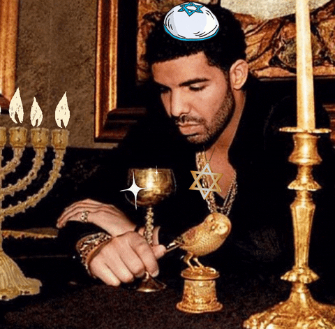 Meme gif. Drake looking sad while wearing a yarmulke and the Star of David, surrounded by candlesticks, a menorah, a goblet and an owl.