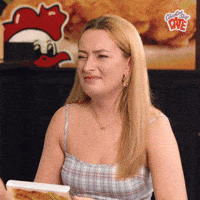 Video gif. Amelia Dimoldenberg, host of Chicken Shop Date, schrunches faces, shakes head, and expresses a look of disgust as she slightly raises hands as if she's questioning why.