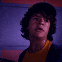 TV gif. Gaten Matarazzo as Dustin on Stranger Things looking annoyed and shocked. Text, "Holy mother of god."
