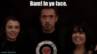 Celebrity gif. Robert Downey Jr. stands in between two smiling women and says confidently, 