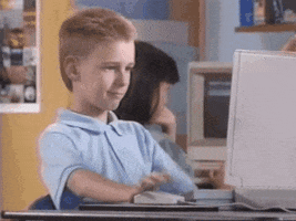 Meme gif. Young boy sits in front of a 1990s-era computer, clicking a mouse. We see the screen; it says, "Bold action against student debt now." The boy looks at the screen and then at us, nodding his head and giving an emphatic thumbs-up.