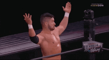 Sports gif. Wrestler Ethan Page stands near the ropes of the ring. He holds his arms up and shrugs. His eyes are wide and he stills his lower lip out.