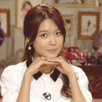 Celebrity gif. K-pop star Choi Soo-young rests her head on her hands and smiles sweetly.