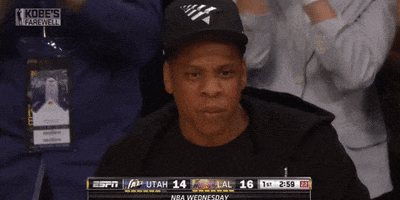 Celebrity gif. Jay-Z nods his head in approval while enjoying a basketball game.