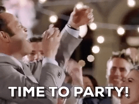 Film gif.  Vince Vaughn als Jeremy Gray in Wedding Crashers propt cake in zijn mond terwijl hij naast de bruid staat en roept: 'Time to party'.