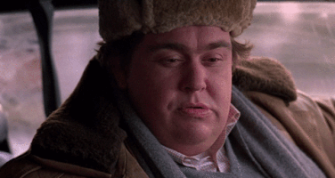 Movie gif. Wearing a furry ushanka and winter coat, John Candy as Buck in Uncle Buck shakes his head slightly and says, “no.”