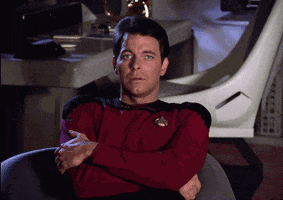 TV gif. Jonathan Frakes as Riker in Star Trek sits in a chair with his arms crossed and he's visibly annoyed as he sighs and prepares to get up.
