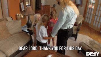 TV gif. Duane Chapman as Dog, the Bounty Hunter and his three young children hold hands in a circle and bow their heads in prayer. Text, "Dear lord, thank you for this day."